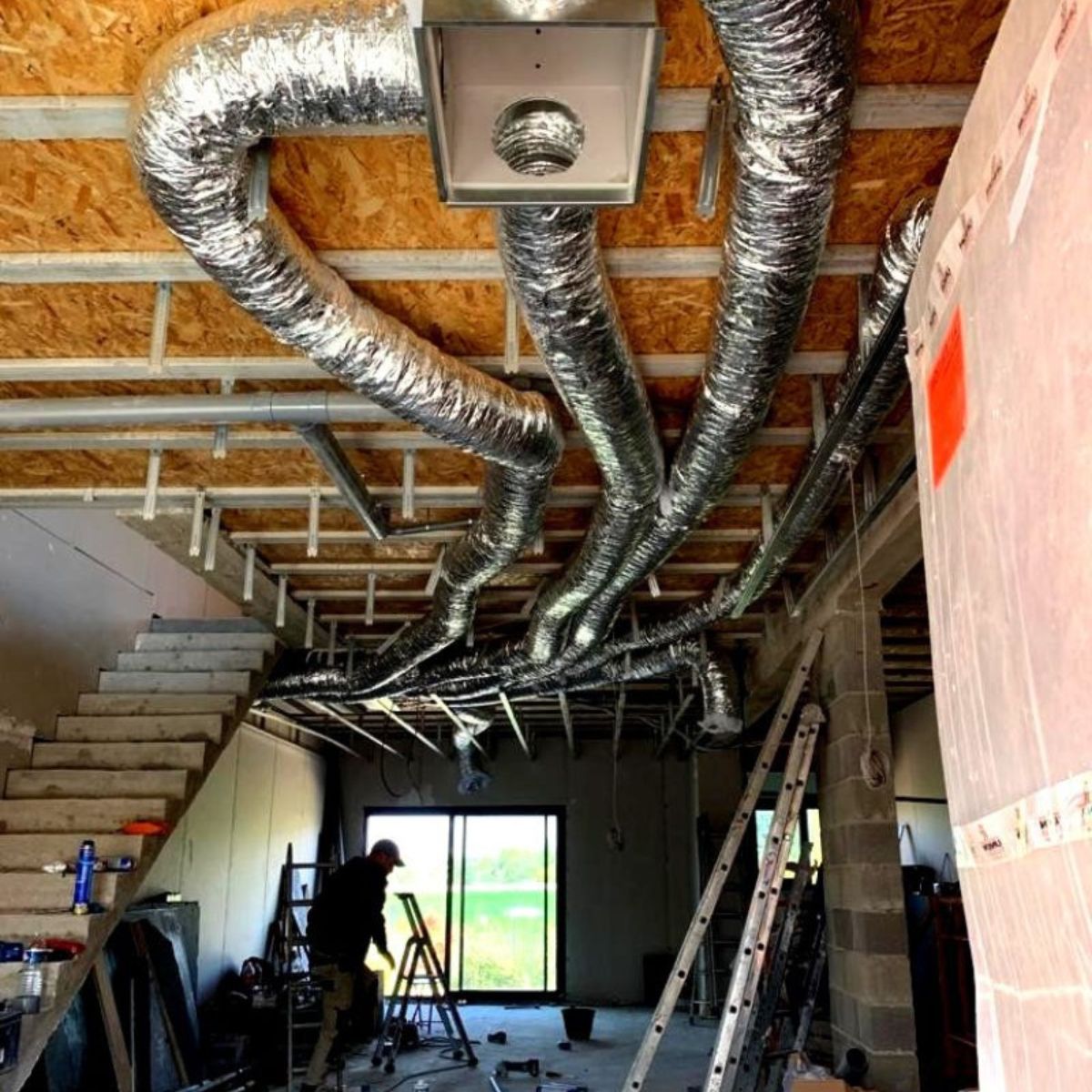 Technicien Proclim installant les gaines d'une climatisation gainable